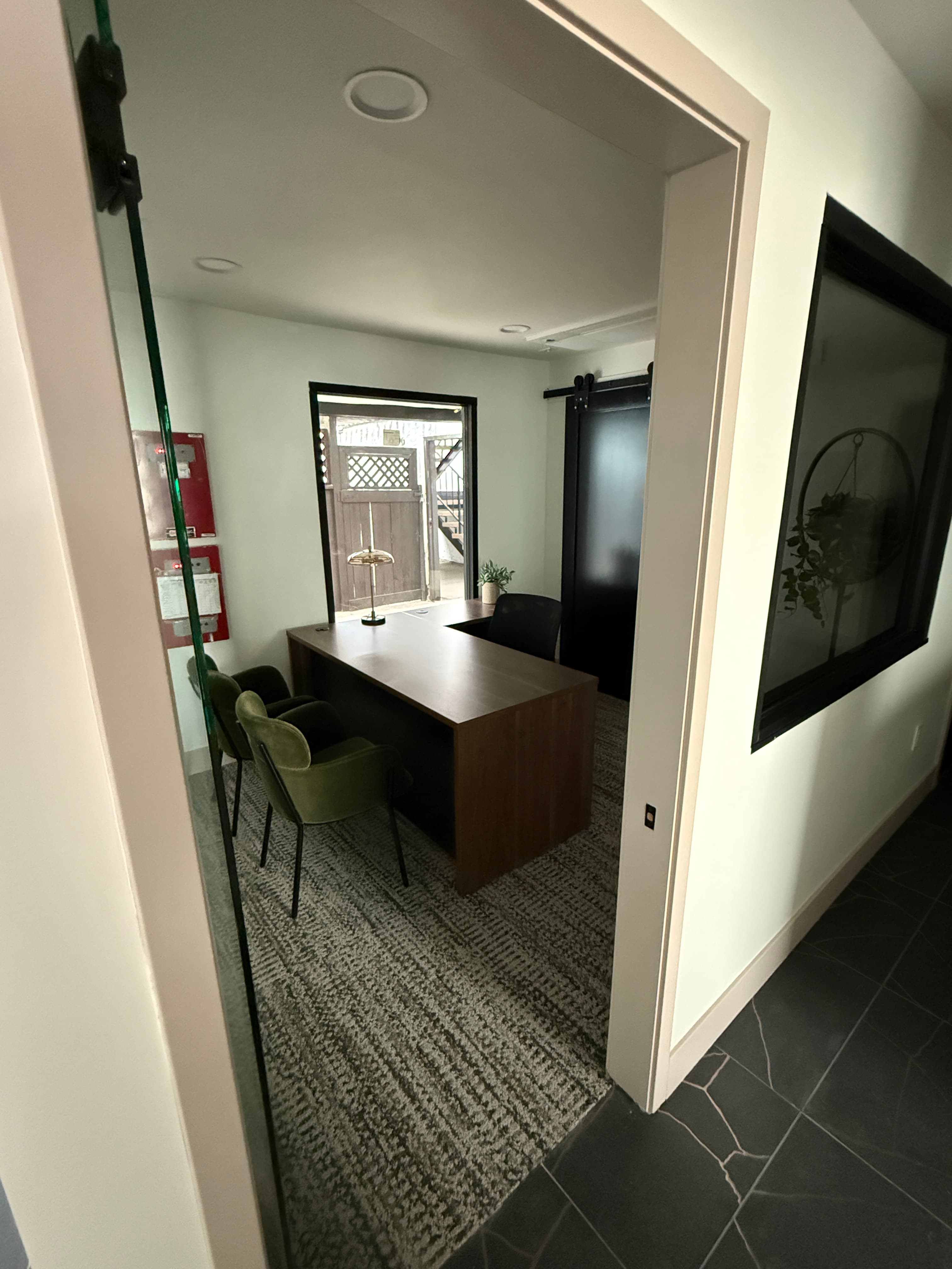 Private leasing office with a wood desk and visitor seating