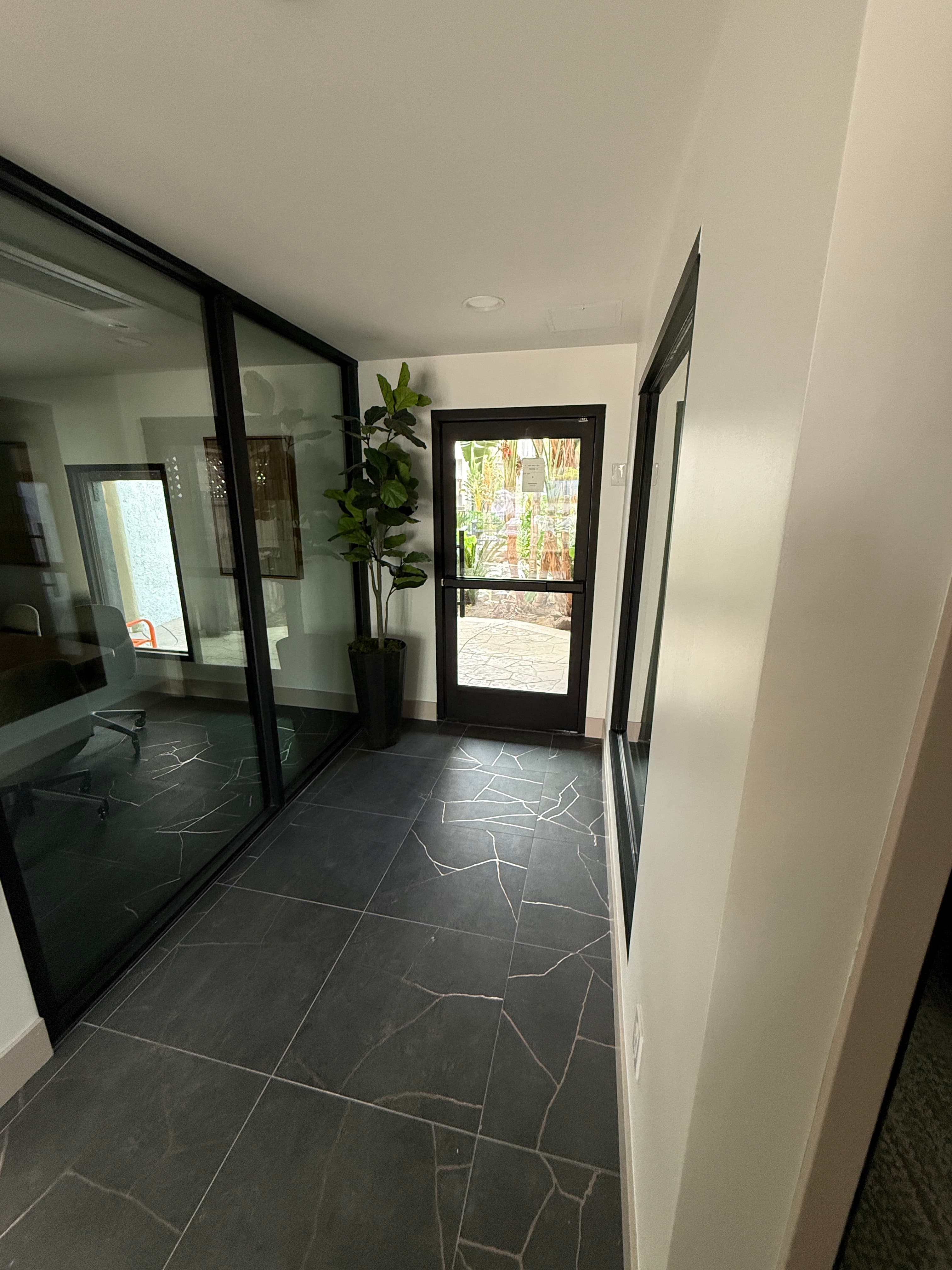 Glass-lined hallway connecting rooms in the new leasing office