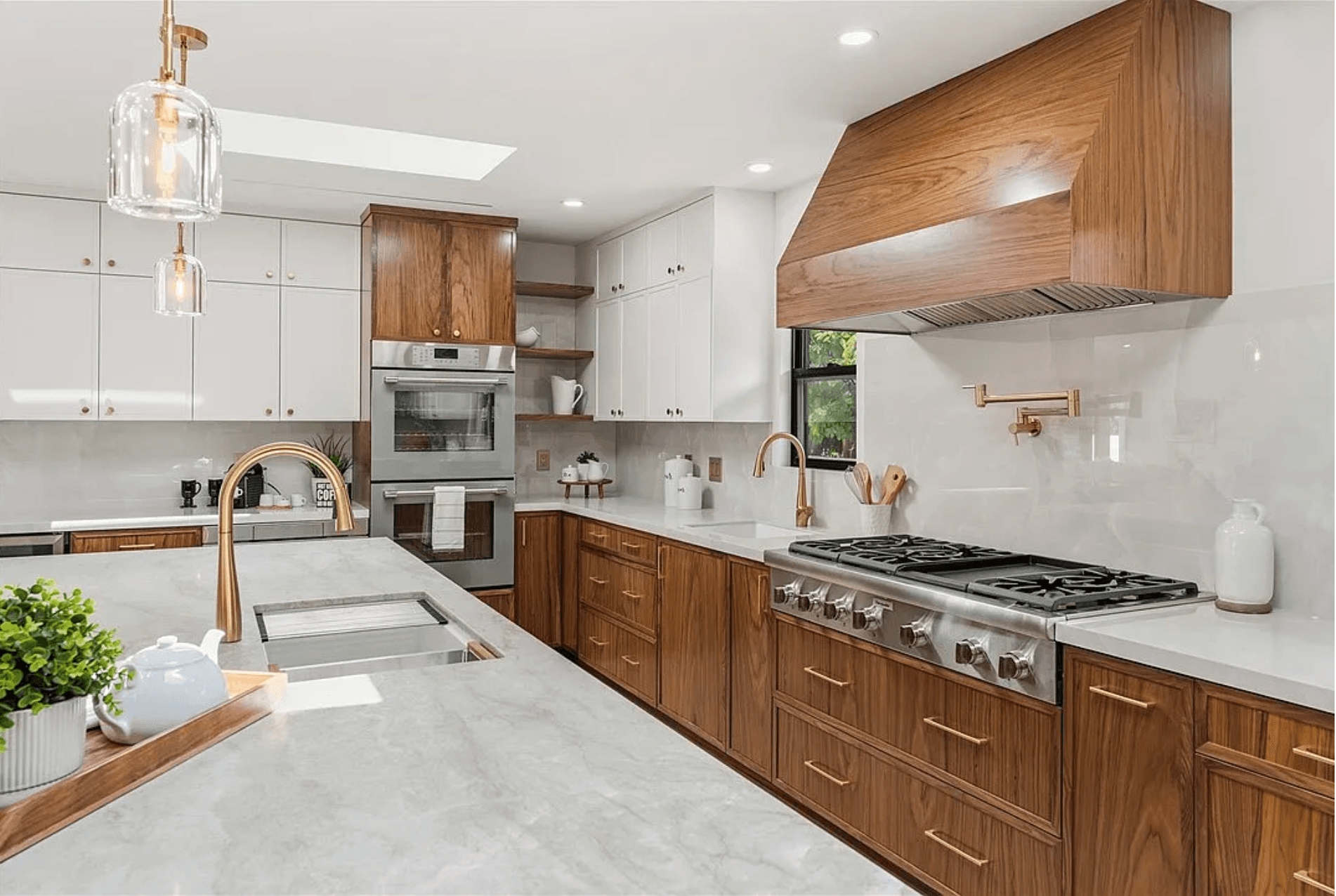 Wood and white kitchen with brass hardware and a custom wood range hood