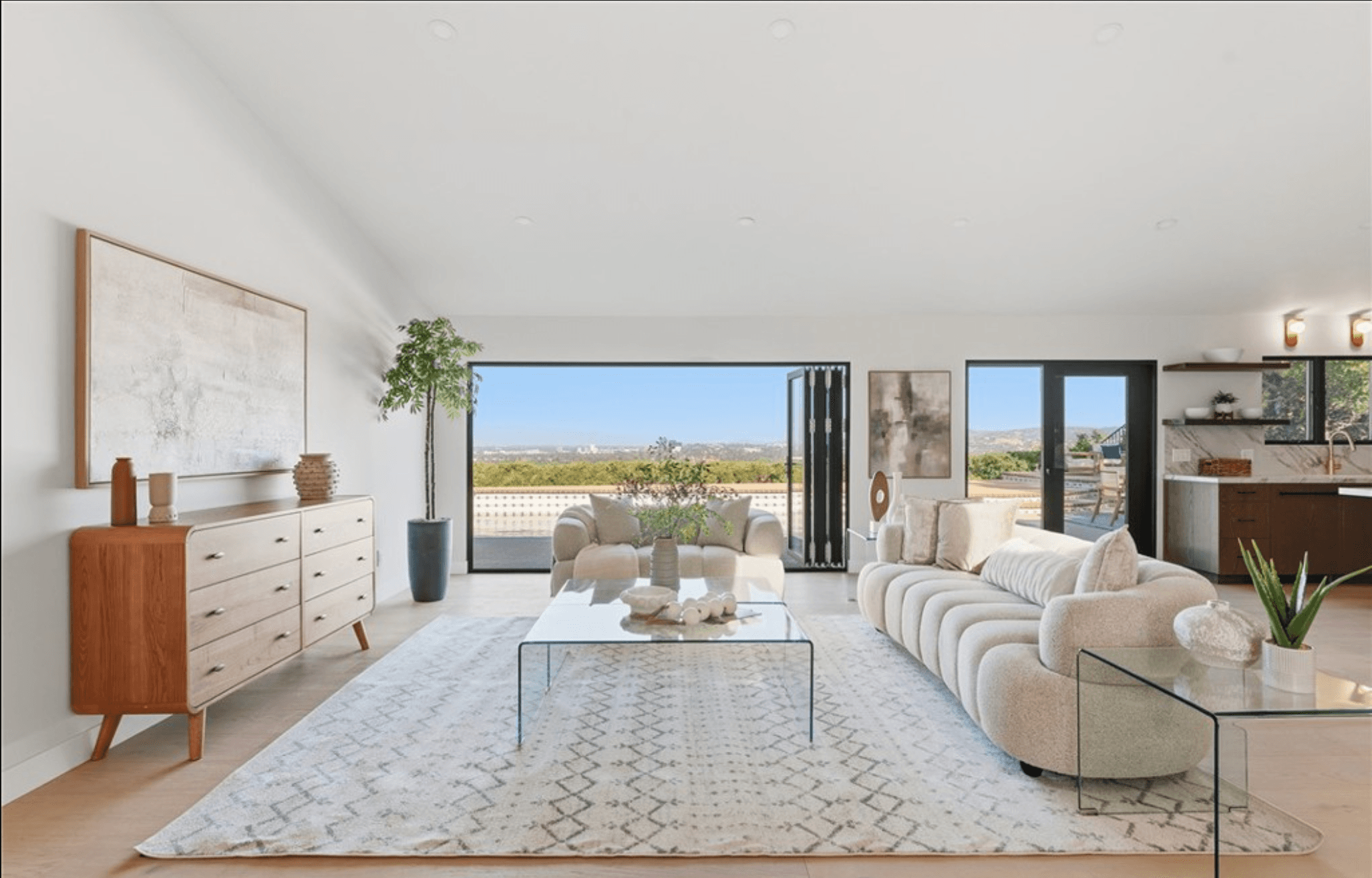 Bright living space opening toward the backyard through folding glass doors